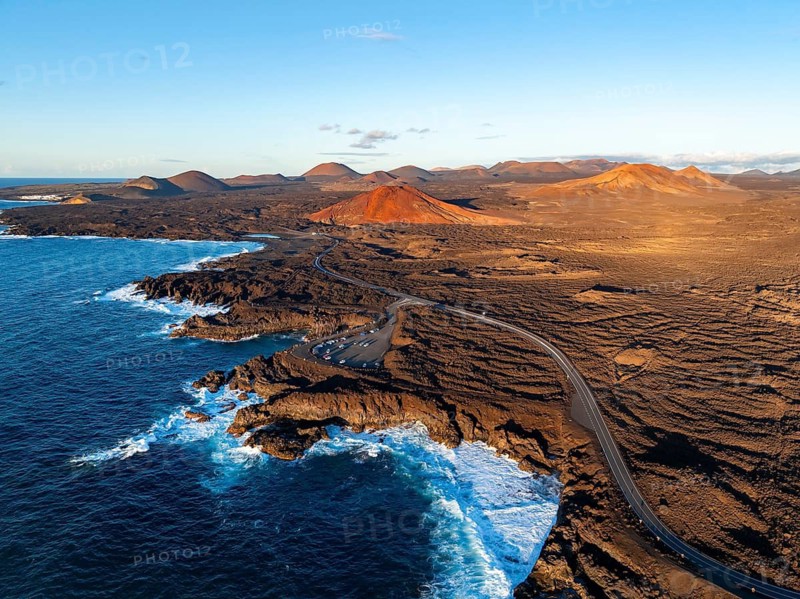Coast with lava fields, volcanic landscape near Los Hervideros with red volcano Montaña Bermeja, in the evening light, aerial view, Lanzarote, Canary Islands, Spain