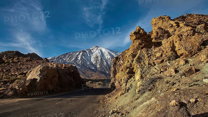 An asphalted road between rocky slopes in a mountainous area under blue sky, Teide, Parque Nacional del Teide, Teide National Park, volcano, volcanism, UNESCO World Heritage Site, Tenerife, Canary Islands, Spain