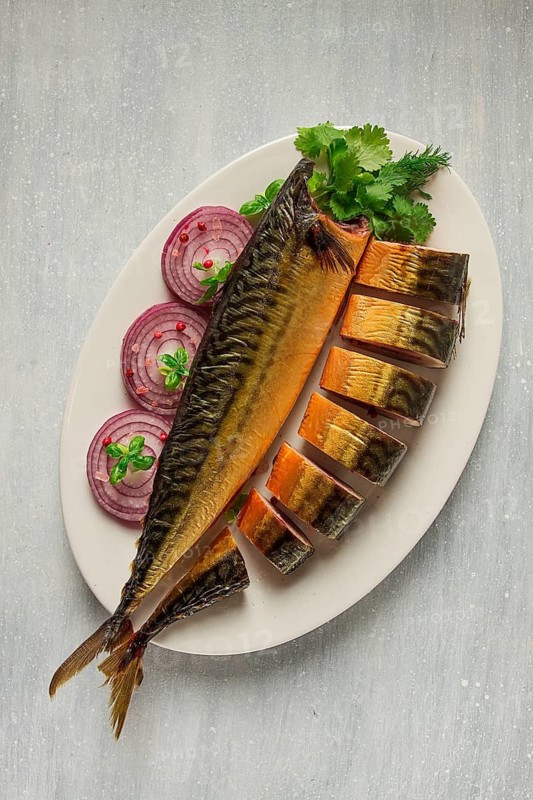 Smoked mackerel, top view, with spices, on a wooden table, no people, selective focus
