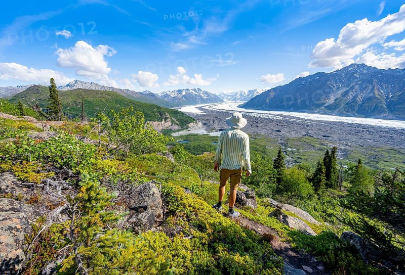 Young man enjoying the view, view of impressive mountain landscape with Matanuska glacier and glaciated mountain peaks, Lion's Head, Chugach Mountains, Alaska, USA