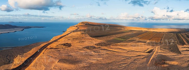 Road on cliffs in evening light, steep cliffs on the coast near Mirador del Porrito, aerial view, at sunset, Lanzarote, Canary Islands, Spain