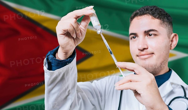 Doctor holding syringe on Guyana flag background. Medical professional holding syringe with Guyanese flag in the background