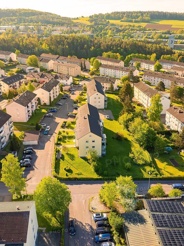 Aerial view of a housing estate with apartment blocks surrounded by hills and green nature, Calw, Black Forest, Germany