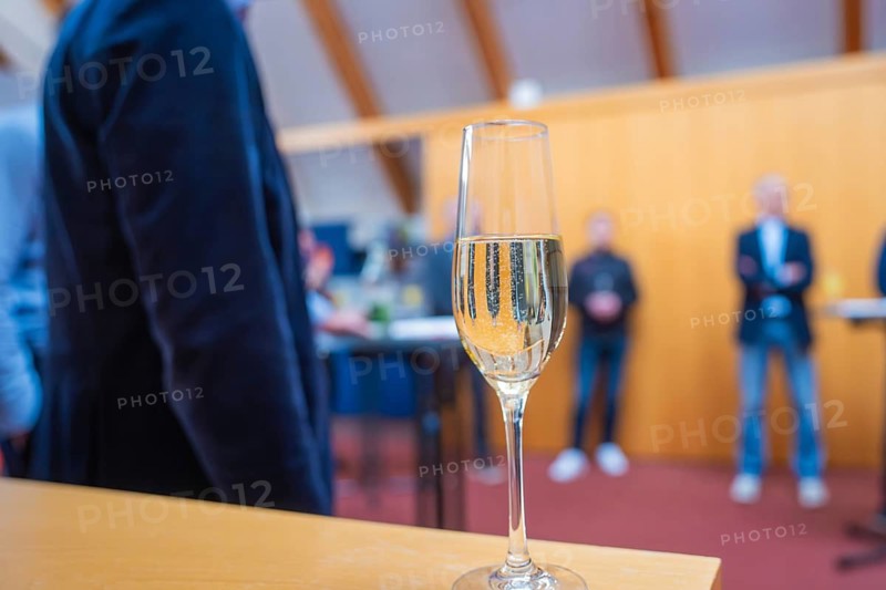 A glass of champagne in front of a group of people standing around the room, fiberglass groundbreaking, Glatten, Freudenstadt district, Germany