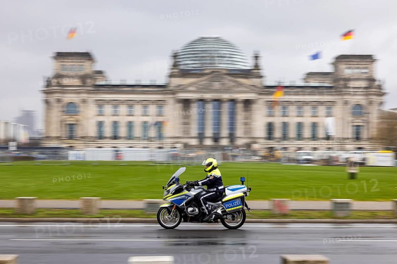 Reichstag Berlin with waving flags. Police motorcycle. Contributor. smudge effect. Berlin, Germany