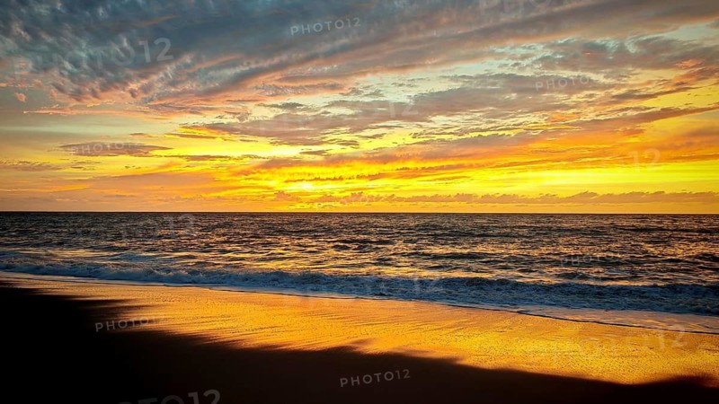 Beach at sunset with vivid colors in the sky and calm waves in the sea, Tarrafal de Monte Trigo, Santo Antao, Cabo Verde, Cape Verde, Cape Verde