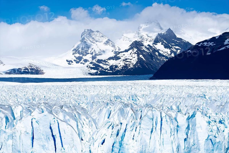 Perito Moreno glacier with rugged ice surface, snow-capped Andean mountain peaks under cloudy sky, Los Glaciares National Park, Santa Cruz Province, Patagonia, Argentina