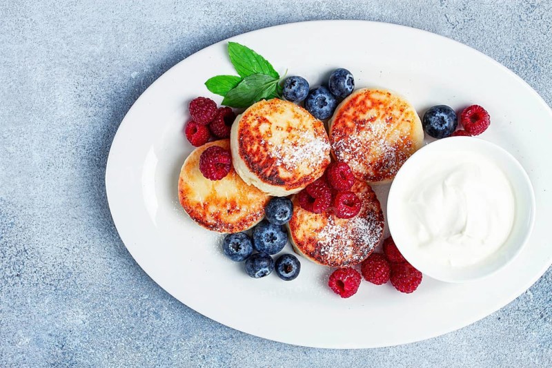 Breakfast, cottage cheese cakes, with fresh berries, and sour cream, top view, close-up, no people
