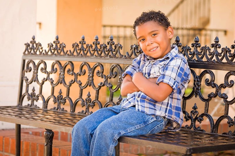 Handsome African American and Mexican Boy Sitting on Park Bench