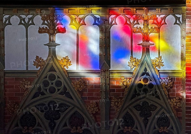 Colored light falls through the stained glass windows in St. Anthony's Church onto a sacred wall painting, interior photo, detail, Papenburg, Emsland, Lower Saxony