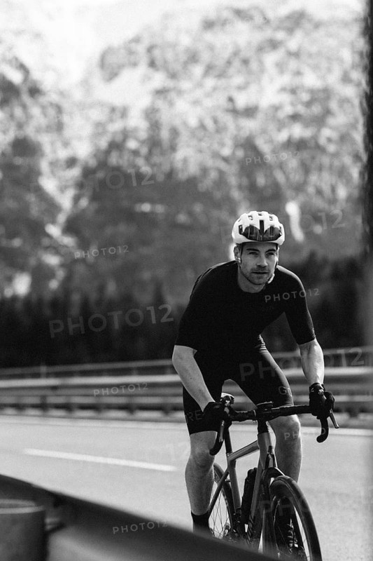 Road bike rider in spring between Lechtal and Tannheimer Tal in front of picturesque scenery of the Alps, Tyrol, Austria