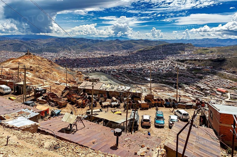View from above of an urban landscape with vehicles, carts and hills under a dramatic sky, The Potosi Silver Mines on Cerro Rico in Bolivia