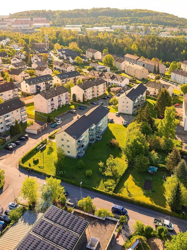Aerial view of a residential area with forests in the background, many roofs and green areas in sunshine, Calw, Black Forest, Germany