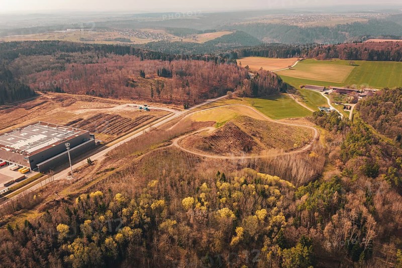 Extensive panoramic view of a hilly area with buildings, roads and surrounding forest, old deposit in front of PV Bau, Lindenrain, Calw, Germany