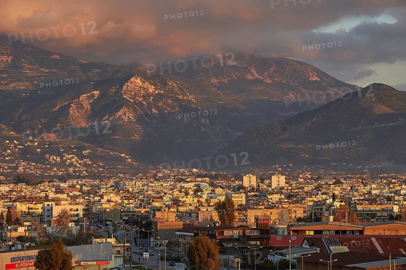Panorama of a city against a mountainous backdrop with dramatic clouds, Patras, Peloponnese, Greece
