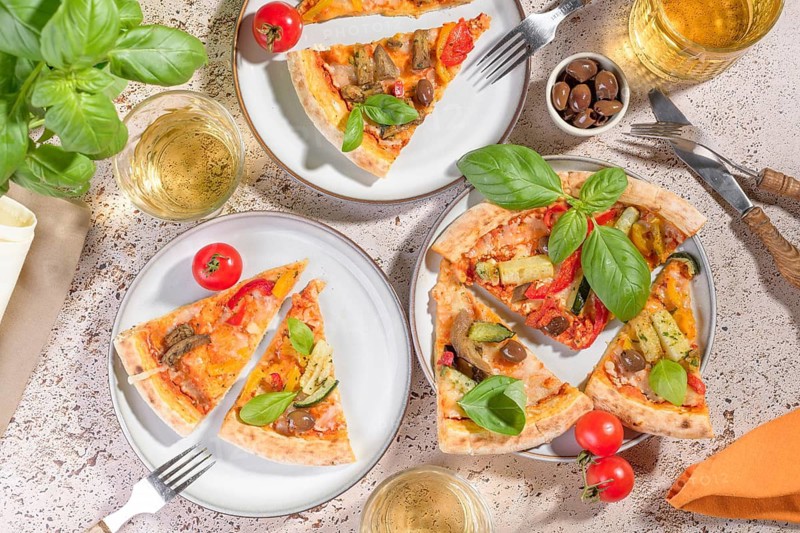 Delicious vegetarian pizza topped with fresh basil, zucchini, and eggplant slices, paired with refreshing drinks. This colorful meal is perfect for a summer lunch or dinner