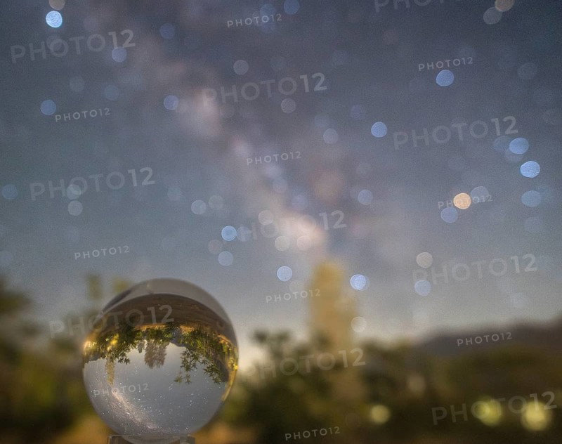 A captivating photo showcasing the Milky Way glittering in the night sky, viewed through a crystal ball at Sequoia National Park, highlighting the parkâ€™s natural beauty and the cosmic spectacle above