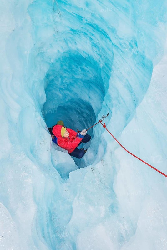 Mountaineer moving up ice cave, Fox Glacier, Westland National Park, South Island, New Zealand