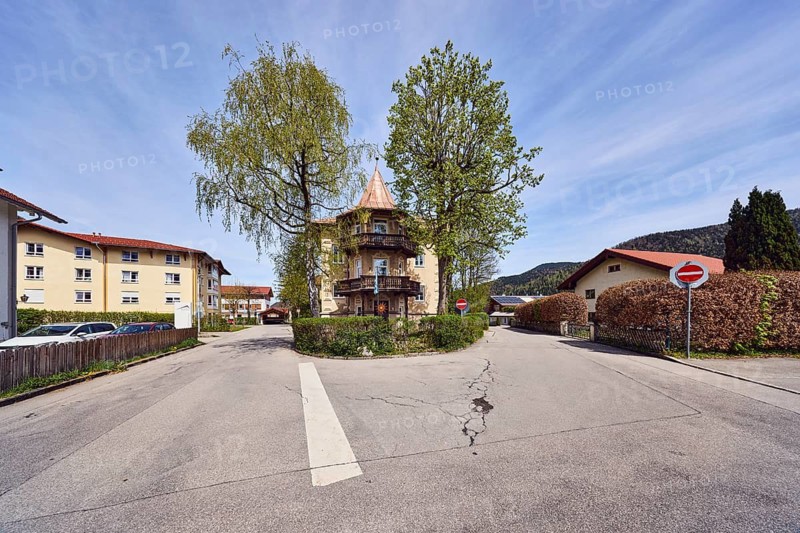 Alpine buildings, general architecture, trees with spring leaves, hedges, roads, hilly landscape, coniferous forest, blue sky, cirrus clouds, confluence of town hall square in Brandstätterstraße, Ruhpolding, Traunstein district, Bavaria, Germany