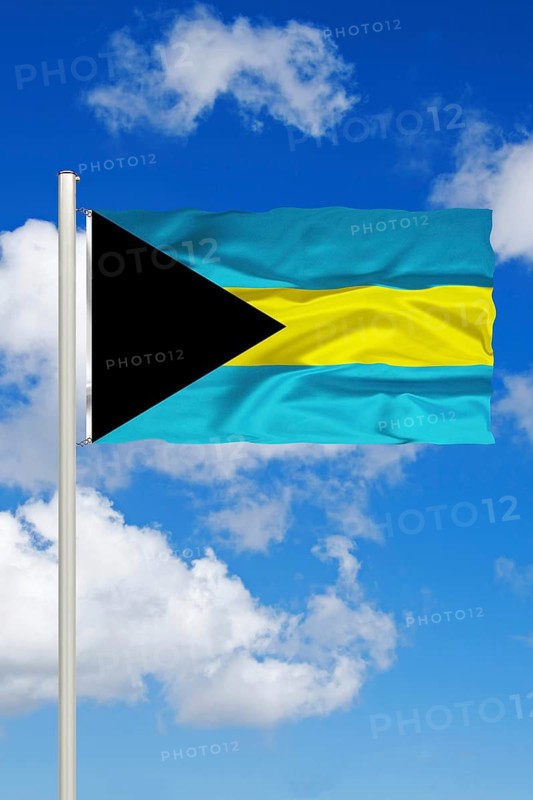 National flag of the Bahamas in front of cumulus clouds and blue sky, Studio