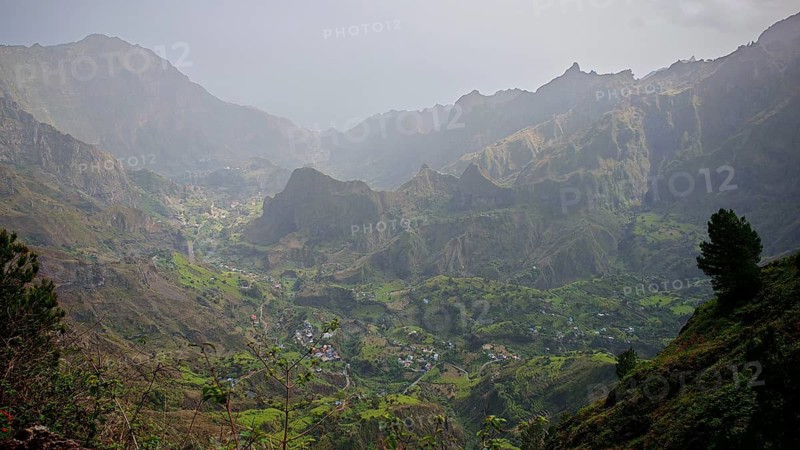 Panoramic, spectacular view over a valley with a winding path, hiking trail and mountains in the background under foggy conditions, hiking from Cova Crater through Paul Valley, Ribeira do Paul to Vila das Pombas, Santo Antao, Cabo Verde, Cape Verde, Cape Verde