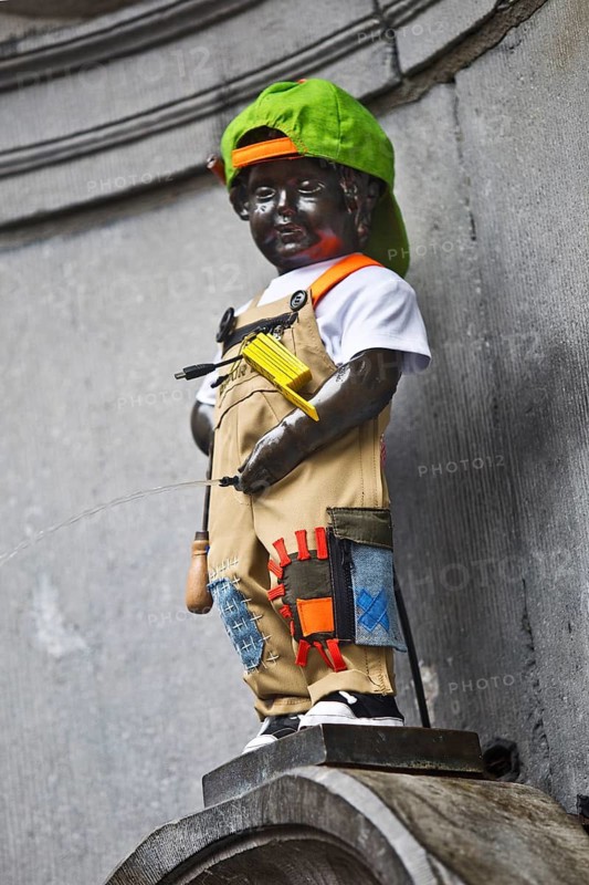 Bronze statue Manneken Pis by Jérôme Duquesnoy, fountain figure of a urinating boy in costume, landmark, Brussels, Belgium