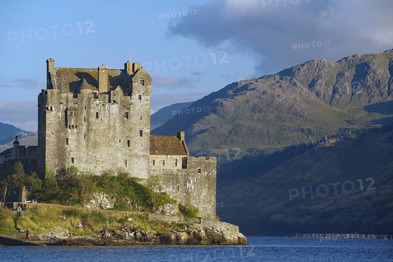 A majestic waterfront castle with mountains in the background under a dramatic sky, film set, Highlander, James Bond, Rob Roy, Eilean Donan Castle, Scotland, Great Britain