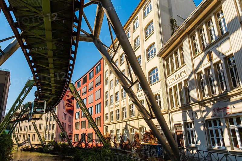 A suspension railway runs between old industrial buildings near the Kluse stop, Wuppertal, Germany