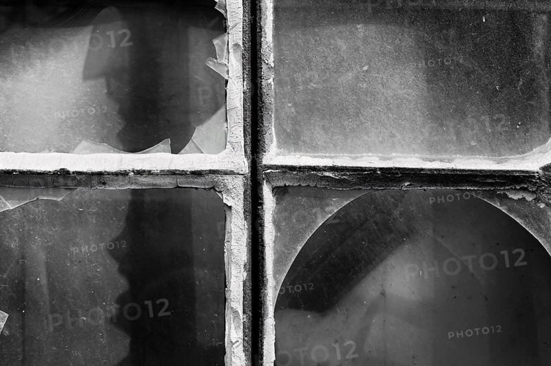 Broken window panes with a human-like screaming face