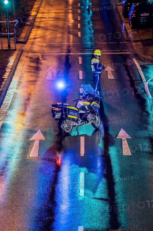 Policeman with motorbike, in rainy weather, blocking a road, police motorbike with blue light