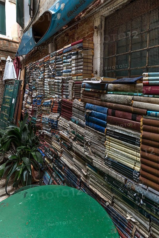 Stacked books on a wall after flood damage in a bookstore, Venice, Veneto, Italy