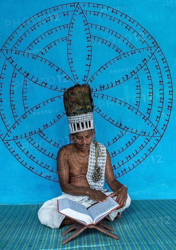 Man from the Ramnami sect reading the Ram Charit Manas, the holy book of the Ramnamis (Chhattisgarh, India), As a sign of devotion, Ramnami people used to tattoo their body and face with the name of Rama, one of the main hindu god. Nowadays, this tradition is disappearing. Indeed, few of them are still tattooed, the younger generation fearing discrimination. The community (or sect) is born in the end of the 19th century as a way to protest against the supremacy of the higher classes in the hindu hierarchical system. Comprised of low caste hindus, they dont accept the caste system, they practise a form of bhakti (devotion) dedicated to the god Rama