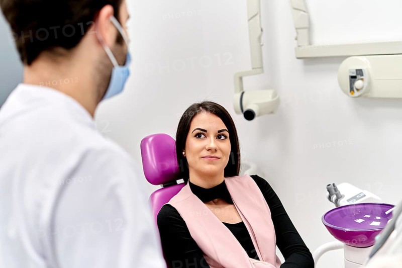 A patient discusses options for facial cosmetic surgery with a doctor in a modern clinic, focusing on enhancing facial features and improving personal confidence
