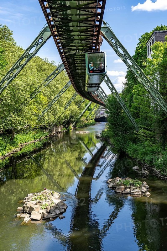 The Wuppertal suspension railway, train of the latest generation 15, floats above the Wupper, North Rhine-Westphalia, Germany