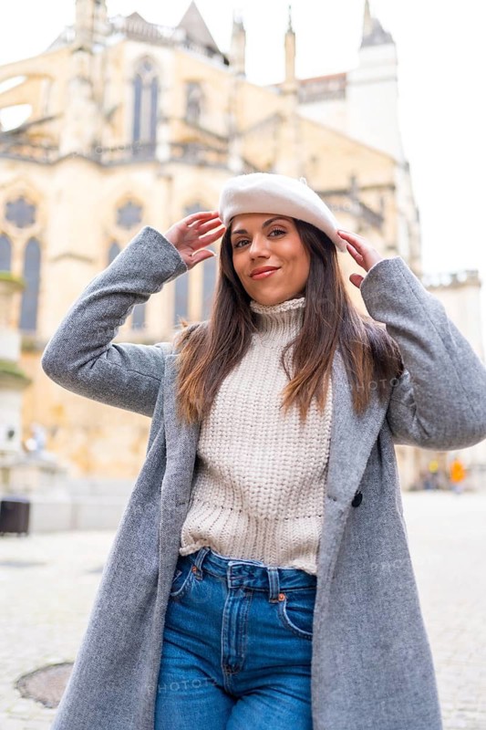 Stylish woman posing smiling at camera in the city in front of a Church