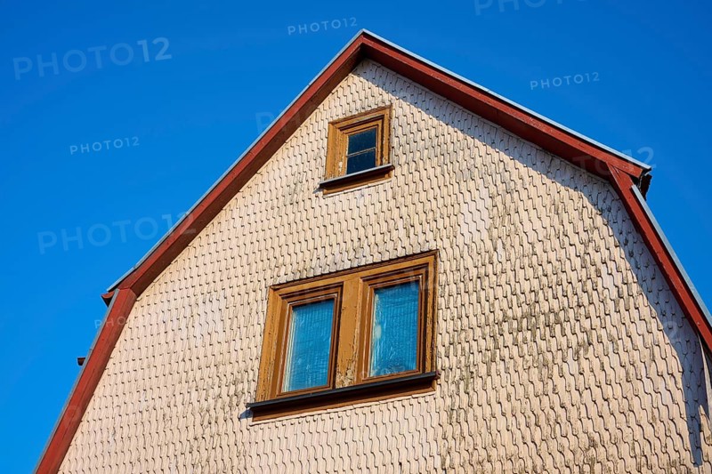 Upper part of a house with gable and windows, framed by a bright blue sky, Erbach, Odenwald, South Hesse, Hesse, Germany
