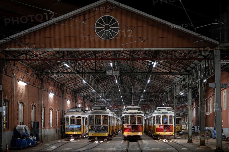 LISBON, PORTUGAL - MAY 19, 2025: Historic trams stand in the tram depot at night