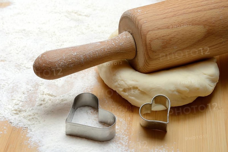 Dough roller on dough and cookie cutter, cake dough