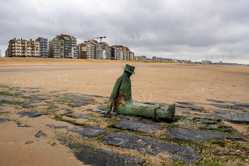 Art on the North Sea beach, in Knokke-Heist, La Mer, ce grand sculpteur, or The Sea, the Great Sculptor, by Jean-Michel Folon, is washed over by the sea at high tide, many permanent works of art in public spaces are spread around the city, here on the beach on the Zeedijk-Knokke, beach promenade, dreary winter day, Belgium