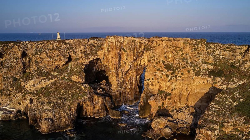 Drone shot, dramatic cliffs with lighthouse and sea in the background in daylight, morning light, Tsichli Babas islet, Sfaktiria island, Navarino Bay, Pylos, Peloponnese, Greece