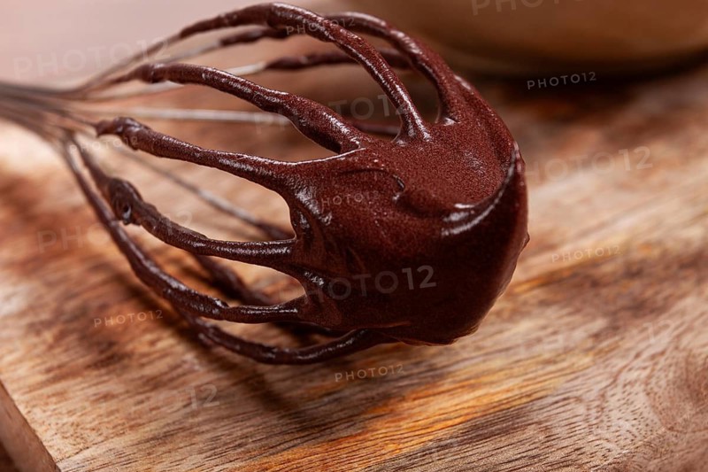 Metal whisk, close-up with chocolate dough, baking, structure and consistency, homemade, top view, no people
