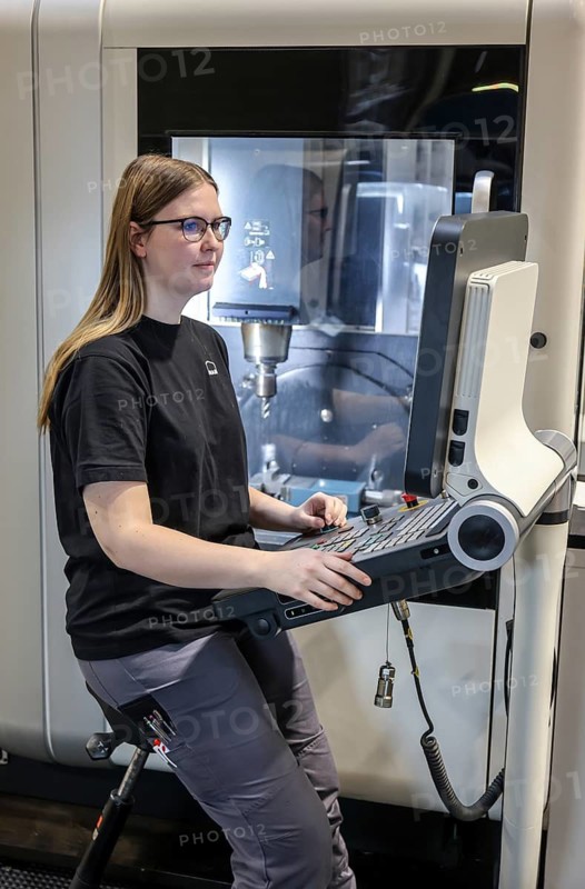 Oberhausen, North Rhine-Westphalia, Germany, Trainee woman in metalworking. Trainee cutting machine operator at a CNC machine tool in the MAN training centre. MAN Energy Solutions is a traditional company in the Ruhr region. Around 2, 000 employees build and develop compressors and turbines at the 250-year-old site in Oberhausen