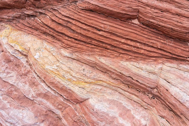 Abstract sandstone texture showcasing layered formations in delicate earth tones, highlighting natural grooves and patterns. Ideal for backgrounds, design, and art inspiration