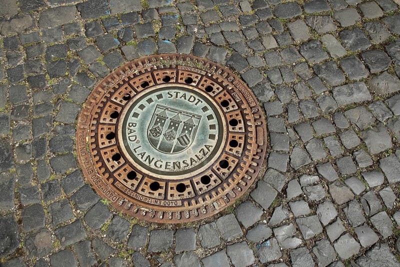 Round manhole cover with city coat of arms and inscription, paving stones, floor, Bad Langensalza, Thuringia, Germany