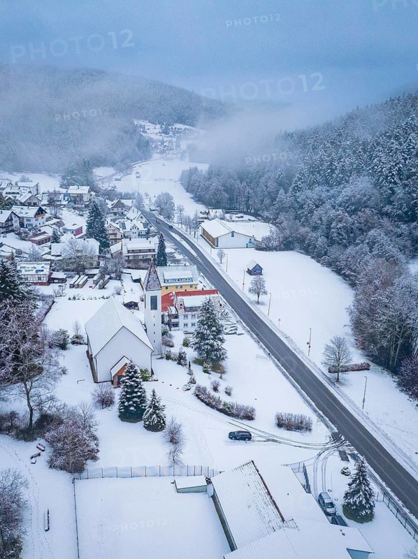 Snow-covered village with church and main street, surrounded by forests, Enzklösterle, Calw district, Black Forest, Germany