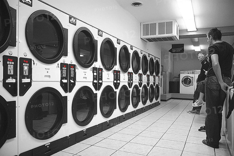 Customers wait for their laundry in a self-service laundromat, black and white, Newton, New Jersey, USA