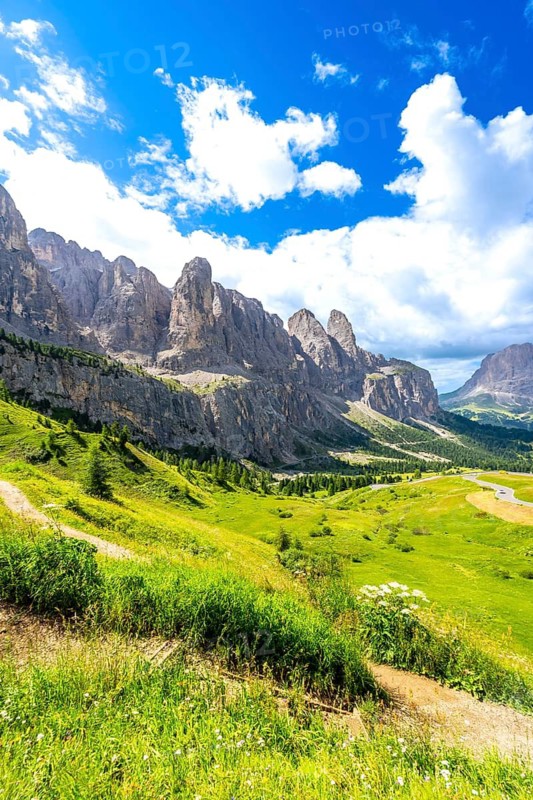 Hiking trail with stunning views of the dolomites mountains and gardena pass on a sunny summer day