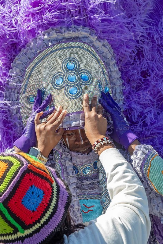 New Orleans, Louisiana - A man is helped with his costume before the Mardi Gras Indians' Super Sunday parade. African-Americans create elaborate costumes for the annual event to honor Native Americans who, during slavery, helped helped people escape and gave them refuge