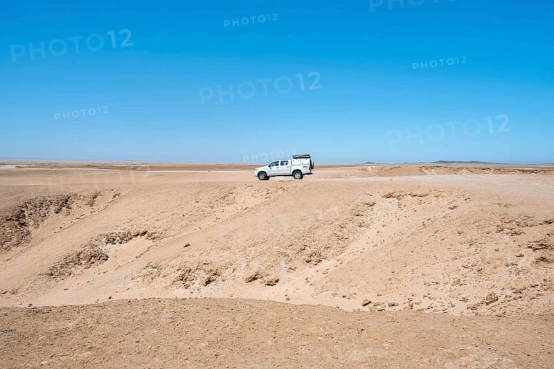 Offroad Car drives trough Rocky landscape, Moon Valley, Namib-Naukluft Park, Namib Desert, Namibia