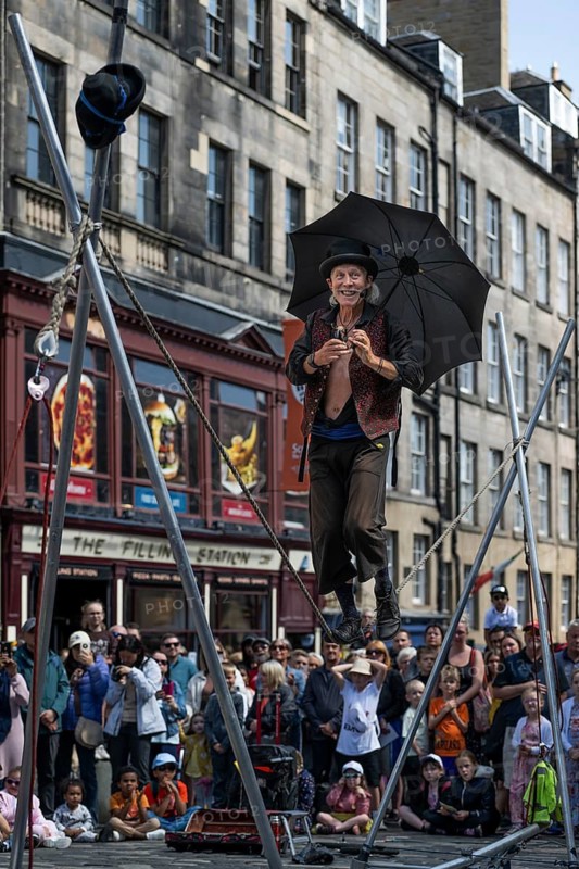 Street performers and spectators at a high-wire acrobatics performance, world's largest cultural festival The Fringe, High Street, Edinburgh, Scotland, United Kingdom, Great Britain
